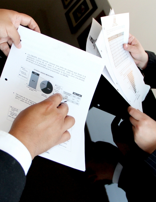 two men looking at printouts of graphs