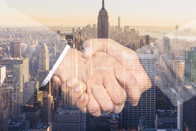 city background with a hand shake superimposed