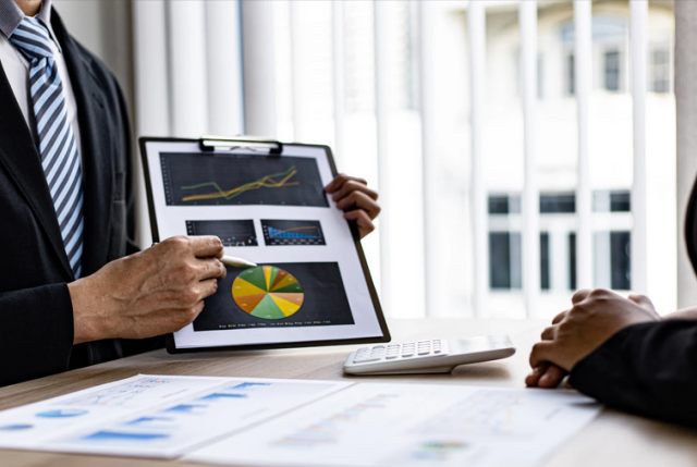 man pointing to a pie chart on a clipboard